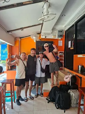 a group of people posing for a picture in a room at Voyagers Hostel in Phi Phi Don