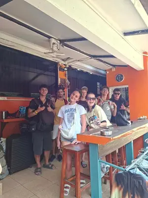 a group of people posing for a picture in a restaurant at Voyagers Hostel in Phi Phi Don