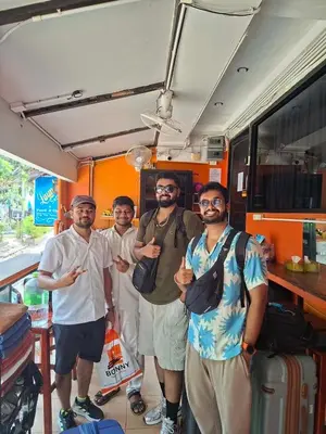 a group of men standing in front of a bus at Voyagers Hostel in Phi Phi Don