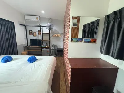 a bedroom with a bed with blue pillows on it at Krabi Nemo House in Ao Nang Beach