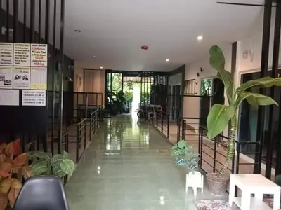 a hallway with plants and chairs in a building at Krabi Nemo House in Ao Nang Beach