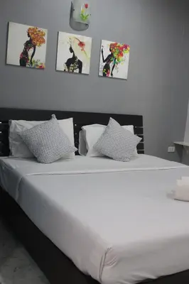 a bedroom with a white bed with pictures on the wall at Krabi Nemo House in Ao Nang Beach