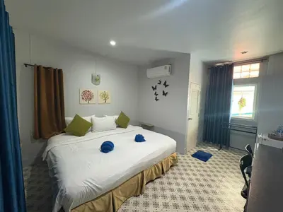 a bedroom with a large white bed with blue pillows at Krabi Nemo House in Ao Nang Beach