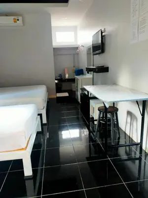 a room with two beds and a desk and a table at Nemo 2 Resort in Ao Nang Beach