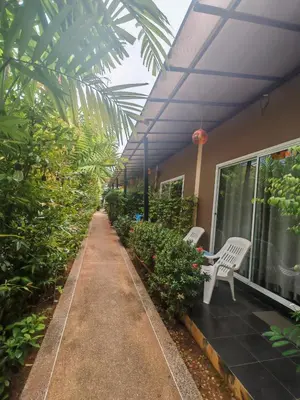 a patio with two white chairs and some plants at Nemo 2 Resort in Ao Nang Beach
