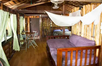a bedroom with a bed and a hammock in a cabin at Sunflower Boathouse in Phi Phi Don