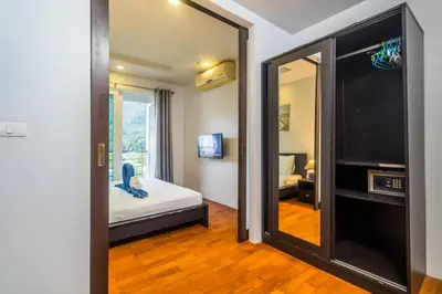 a bedroom with a mirror and a bed and a television at Heaven Lagoon Condo by Lofty in Patong Beach