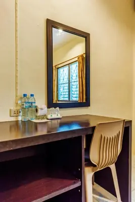 a desk with a mirror and a chair in a room at Baantonsai Garden Resort in Patong Beach