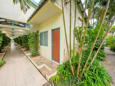 a building with a red door and some plants at Baantonsai Garden Resort in Patong Beach