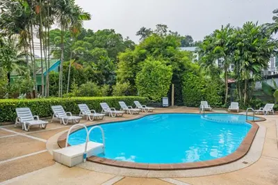 a swimming pool with chairs and a bunch oficans at Baantonsai Garden Resort in Patong Beach