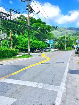 an empty street with yellow arrows on the road at Baantonsai Garden Resort in Patong Beach