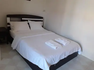 a bedroom with a bed with two towels on it at NB House in Karon Beach