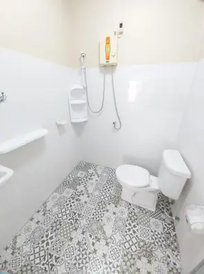 a white bathroom with a toilet and a shower at NB House in Karon Beach