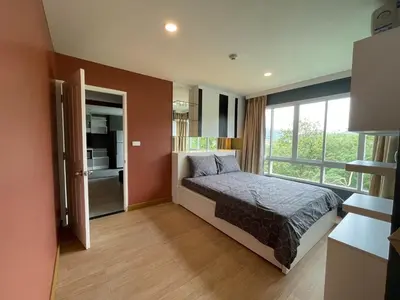 a bedroom with a bed and a large window at Risa Plus2 in Kathu