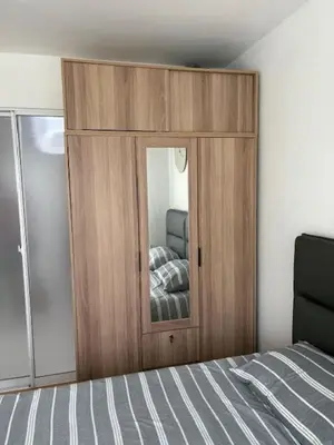 a bedroom with a wooden cabinet with a mirror at Risa Plus2 in Kathu