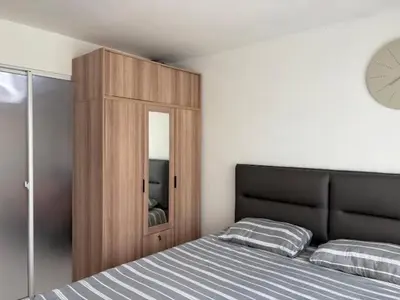 a bedroom with a bed and a wooden cabinet at Risa Plus2 in Kathu