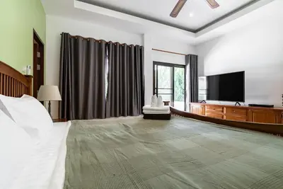 a bedroom with a bed and a flat screen tv at Villa Andre by VillaCarte in Nai Harn Beach