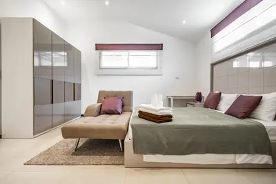 a bedroom with a bed and a chair at Villa Andre by VillaCarte in Nai Harn Beach