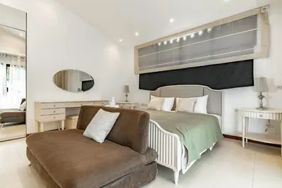 a bedroom with a bed and a couch and a mirror at Villa Andre by VillaCarte in Nai Harn Beach