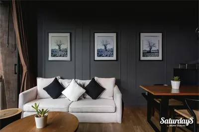 a living room with a white couch and pictures on the wall at Saturdays Residence by Brown Starling in Rawai Beach