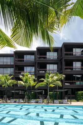 an apartment building with a swimming pool and palm trees at Saturdays Residence by Brown Starling in Rawai Beach