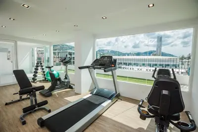 a gym with exercise equipment and a large window at The Bloc Hotel Phuket in Patong Beach