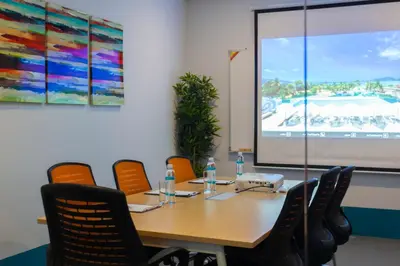 a conference room with a table and chairs and a screen at The Bloc Hotel Phuket in Patong Beach