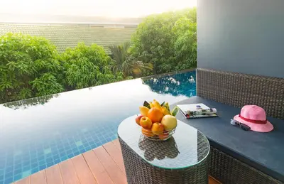 a bowl of fruit on a table next to a pool at AVA SEA Resort Krabi, Ao Nang Beach in Ao Nang Beach