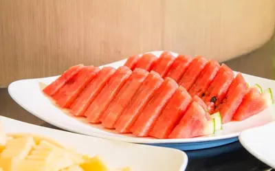 two white plates filled with watermelons on a table at AVA SEA Resort Krabi, Ao Nang Beach in Ao Nang Beach