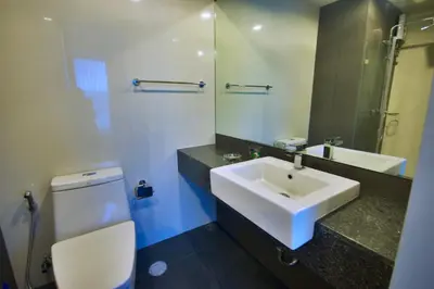 a bathroom with a sink and a toilet and a mirror at 6th Avenue Surin by Risa in Surin Beach