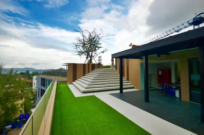a balcony with green grass and stairs on a building at 6th Avenue Surin by Risa in Surin Beach
