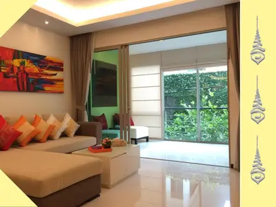 a living room with a couch and a large window at Apt S104 Kamala Regent in Kamala Beach
