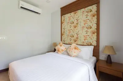 a bedroom with a white bed with a floral wallpaper at Alisea Pool Villa Aonang in Ao Nang Beach