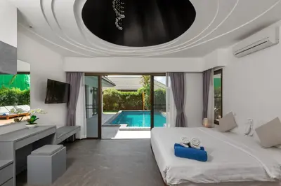 a bedroom with a large bed and a swimming pool at Karon Beach Pool Villa - Sha Extra Plus in Karon Beach