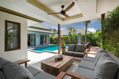 an outdoor living room with a couch and a table at Karon Beach Pool Villa - Sha Extra Plus in Karon Beach