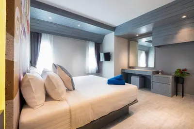 a bedroom with a large bed and a desk at Karon Beach Pool Villa - Sha Extra Plus in Karon Beach