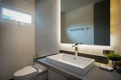 a bathroom with a sink and a toilet and a mirror at Karon Beach Pool Villa - Sha Extra Plus in Karon Beach