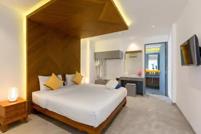 a bedroom with a large bed and a kitchen at Karon Beach Pool Villa - Sha Extra Plus in Karon Beach
