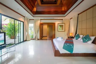a bedroom with a large bed and a television at VILLA PAGAI Pool Baan Bua Estate Naiharn in Rawai Beach