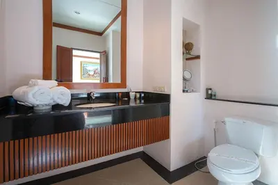 a bathroom with a sink and a toilet and a mirror at VILLA PAGAI Pool Baan Bua Estate Naiharn in Rawai Beach