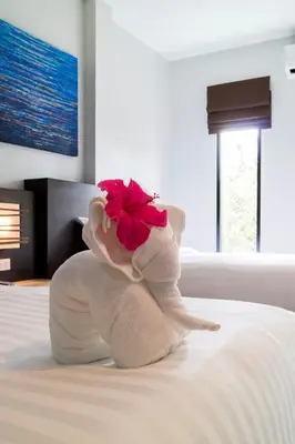 a towel animal with a flower on a bed at S2 Residence in Ao Nang Beach