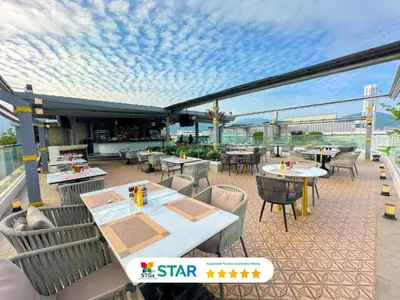 a restaurant with tables and chairs on a patio at Clarian Hotel Beach Patong in Patong Beach