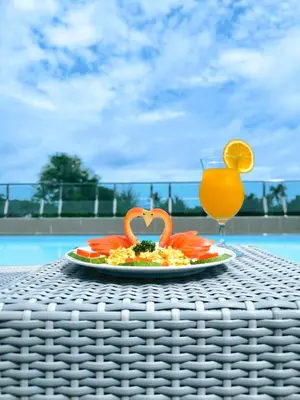 a plate of food and a glass of orange juice at Clarian Hotel Beach Patong in Patong Beach