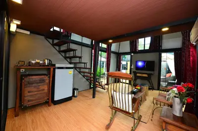 a living room with a spiral staircase and a room with a television at Bukit Pool Villas - SHA Extra Plus in Patong Beach