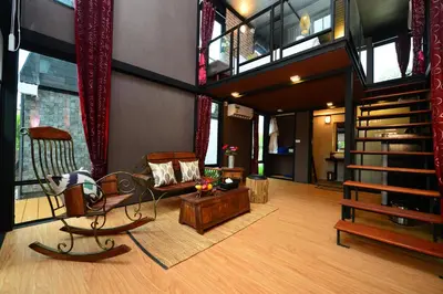 a living room with a staircase and a couch at Bukit Pool Villas - SHA Extra Plus in Patong Beach