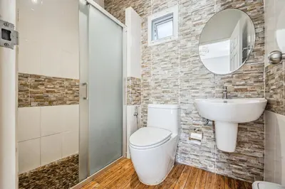 a bathroom with a toilet and a sink and a mirror at Winrisa Place in Nai Yang Beach