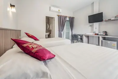 a hotel room with two beds with red pillows at Winrisa Place in Nai Yang Beach