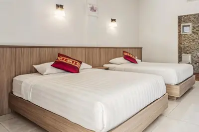 two beds in a room with white and red pillows at Winrisa Place in Nai Yang Beach