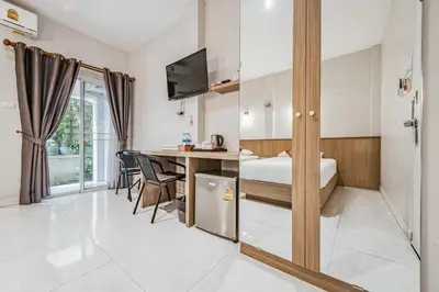 a hotel room with a bed and a desk and a table at Winrisa Place in Nai Yang Beach