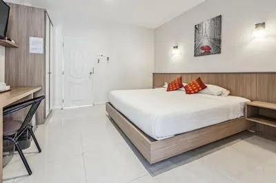 a bedroom with a large bed and a desk at Winrisa Place in Nai Yang Beach